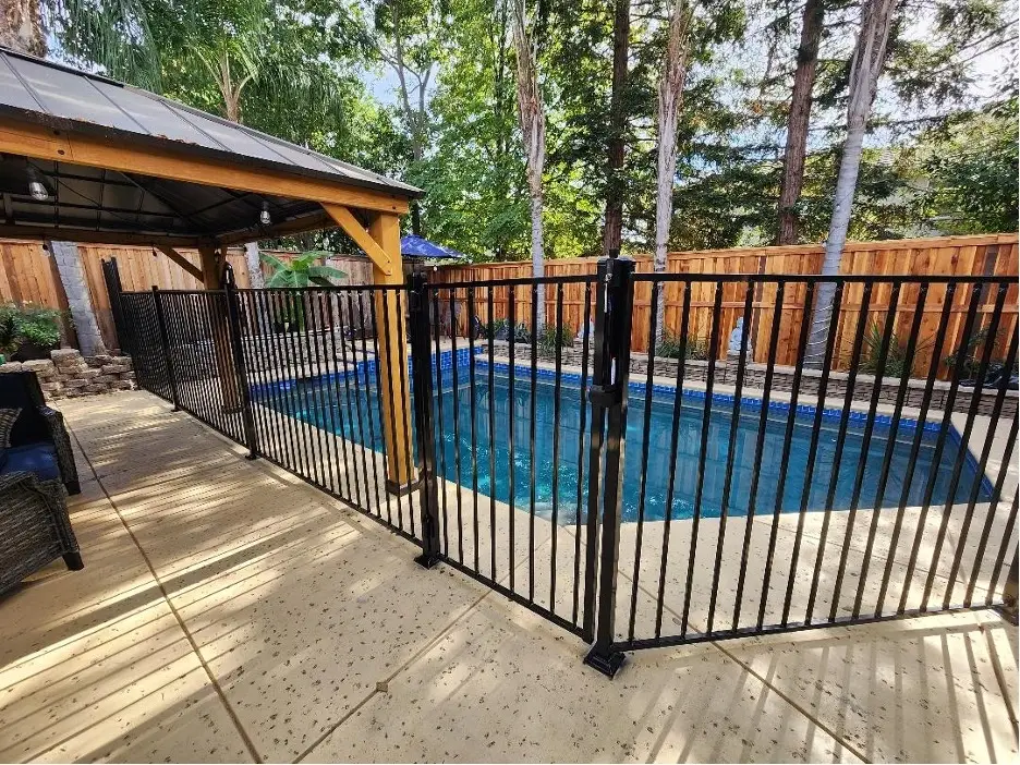 A black iron fence surrounding a pool area, offering safety and security.