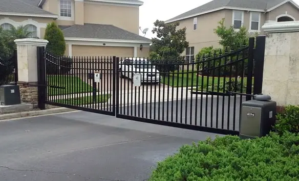 A black electric gate system in a residential area, providing secure access.
