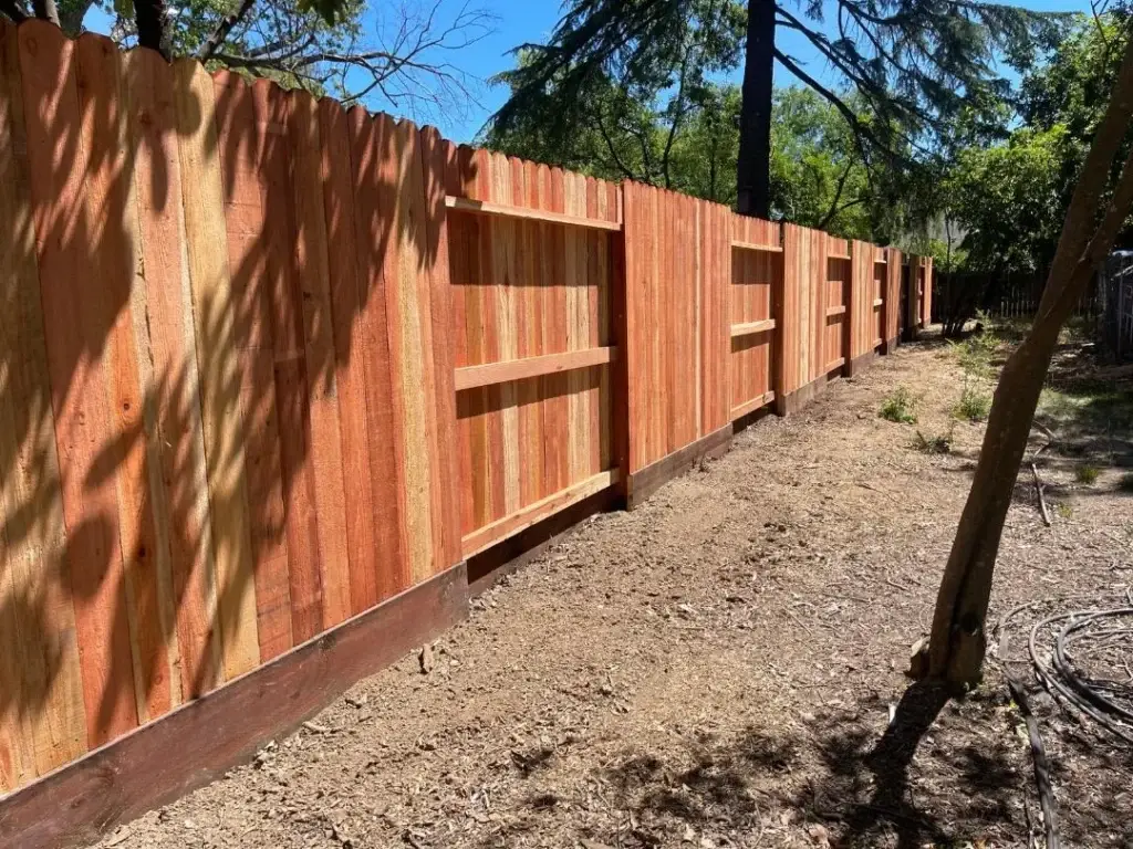 A well-constructed wooden fence in a residential backyard in Sacramento County.