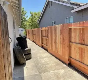 Newly constructed wooden privacy fence in a side yard showing quality superior to an average DIY project